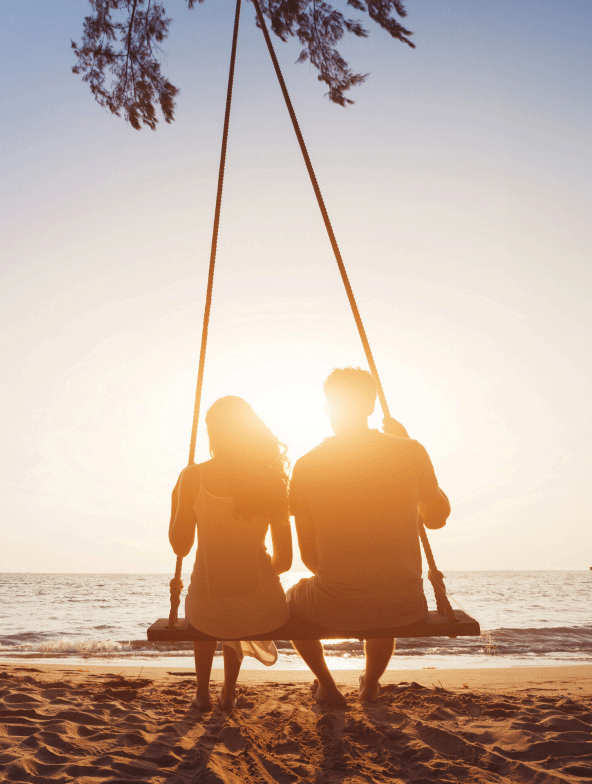 couple watching sunset while on the swing