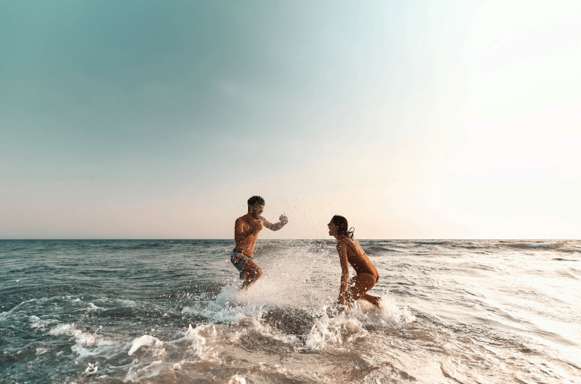 cute couple playing at the beach image